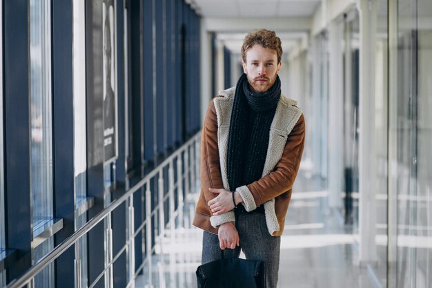 Hombre guapo joven que viaja con bolsa