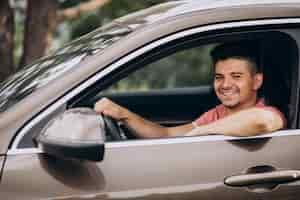 Foto gratuita hombre guapo joven sentado en el coche