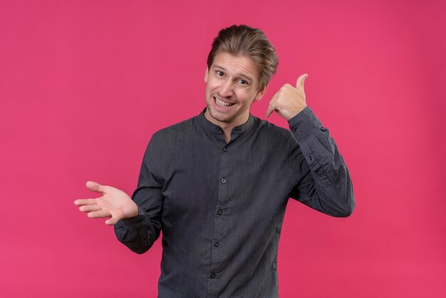 Hombre guapo joven sonriendo haciendo gesto de llamarme