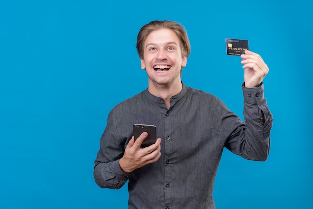 Foto gratuita hombre guapo joven con teléfono móvil y tarjeta de crédito