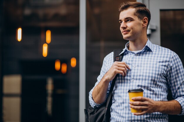 Hombre guapo joven tomando café fuera