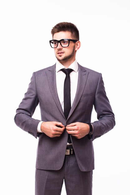 Hombre guapo joven en traje negro y gafas sonriendo aislado sobre fondo blanco.