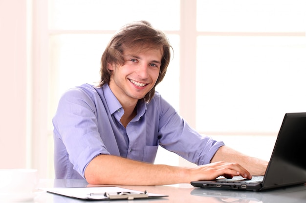 Hombre guapo joven usando laptop