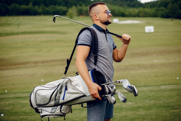 Hombre guapo jugando al golf en un campo de golf