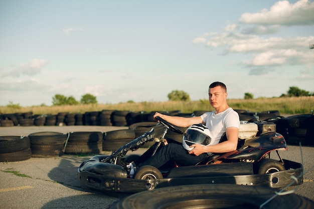 Hombre guapo en un karting con un auto