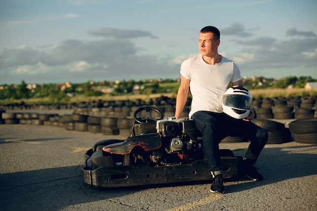 Foto gratuita hombre guapo en un karting con un auto