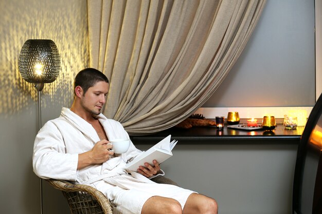 Hombre guapo leyendo un libro