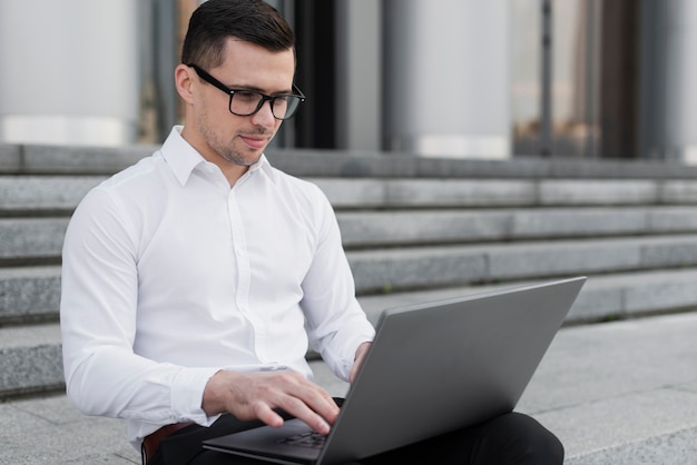 Foto gratuita hombre guapo mirando en la computadora portátil