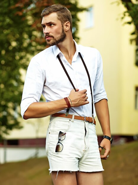 Hombre guapo modelo hipster en ropa de verano elegante posando