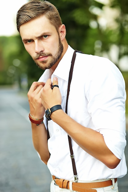 Hombre guapo modelo hipster en ropa de verano elegante posando