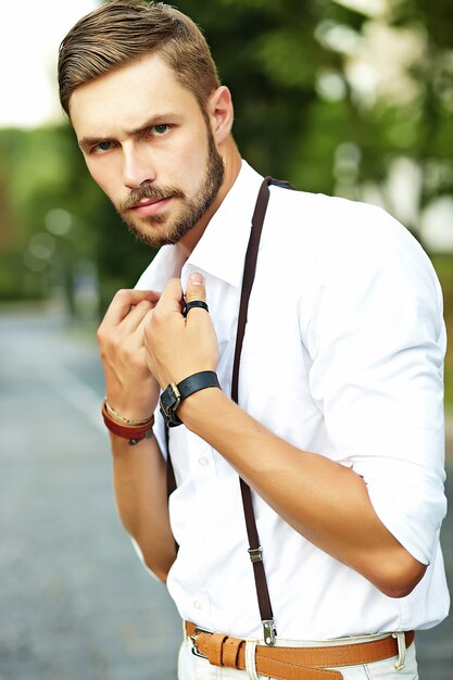 Hombre guapo modelo hipster en ropa de verano elegante posando