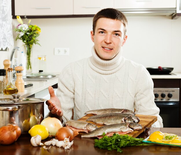 Hombre guapo con peces trucha