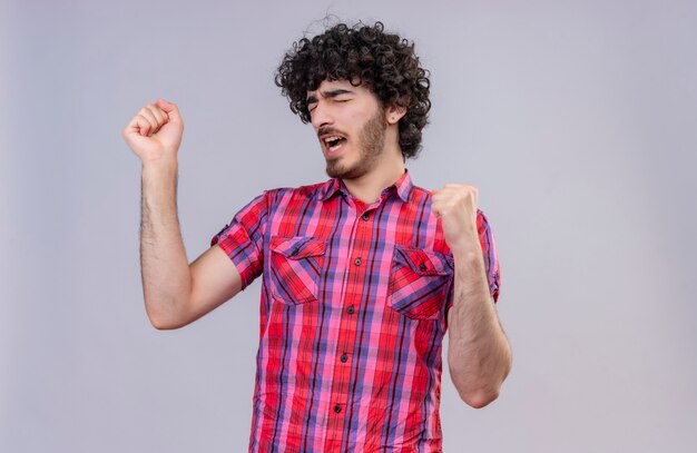 Un hombre guapo con el pelo rizado en camisa a cuadros se siente mal y tiene dolor