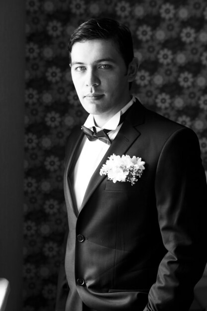 Hombre guapo de pie y mirando en traje de boda. en blanco y negro