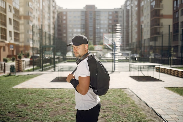 Hombre guapo de pie en un parque con auriculares