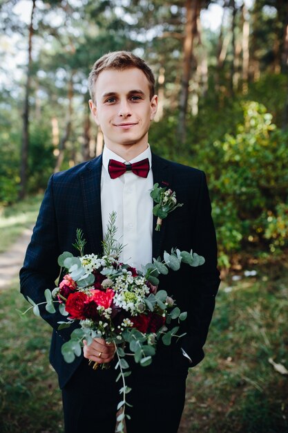 Hombre guapo de pie con ramo de flores