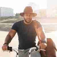 Foto gratuita hombre guapo posando en bicicleta