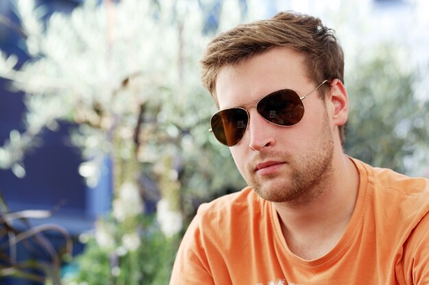 Hombre guapo posando en gafas de sol
