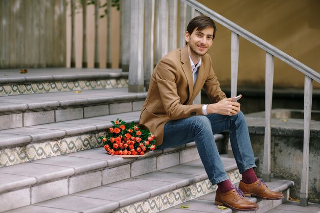 Hombre guapo con ramo de rosas