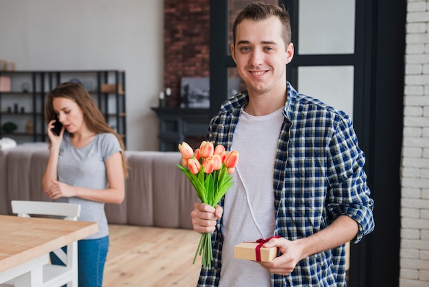 Hombre guapo con regalos para esposa