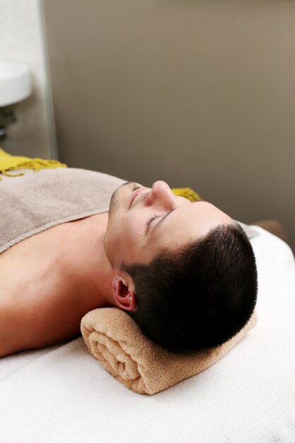 Hombre guapo relajante en un spa