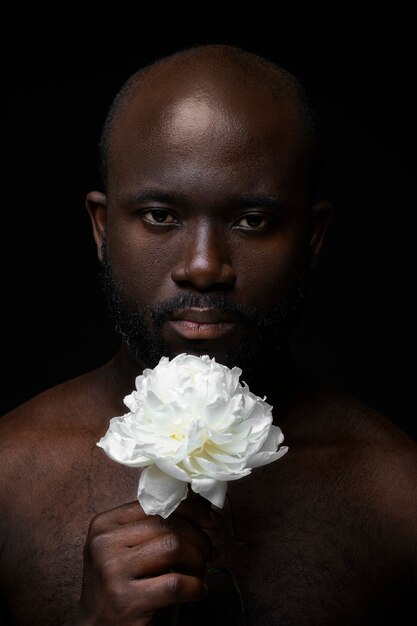 Hombre guapo y sensible con flor.