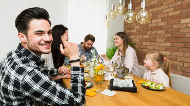 Hombre guapo sentado con amigos en el café