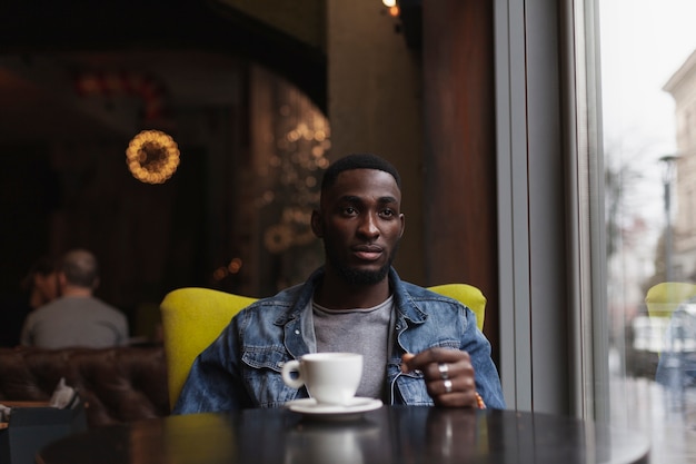 Hombre guapo sentado en la cafetería