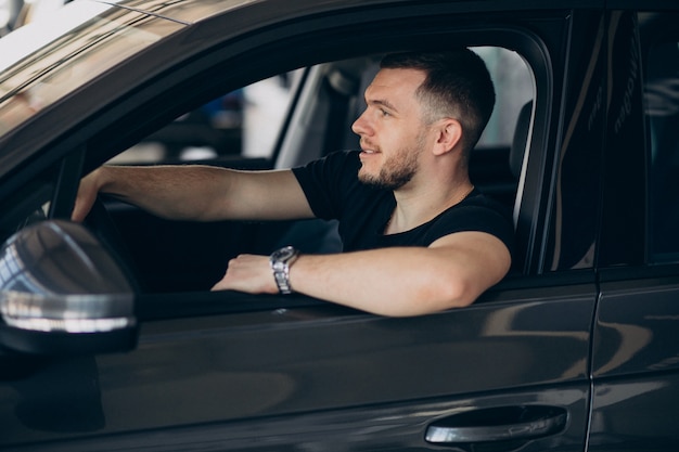 Foto gratuita hombre guapo sentado en el coche y probarlo