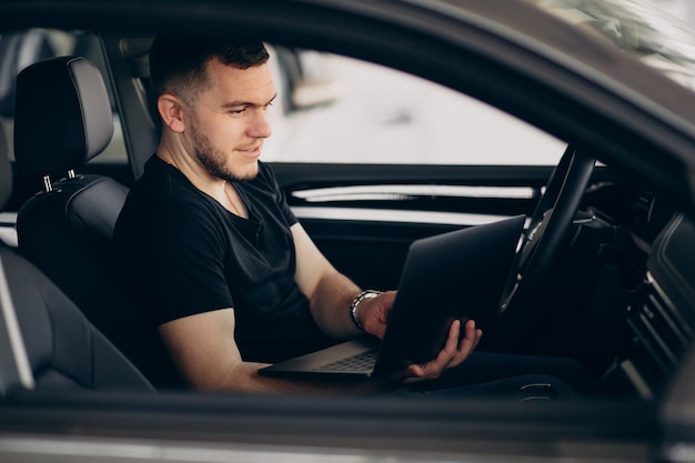 Hombre guapo sentado en el coche y probarlo