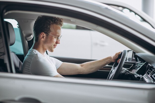 Hombre guapo sentado en un coche