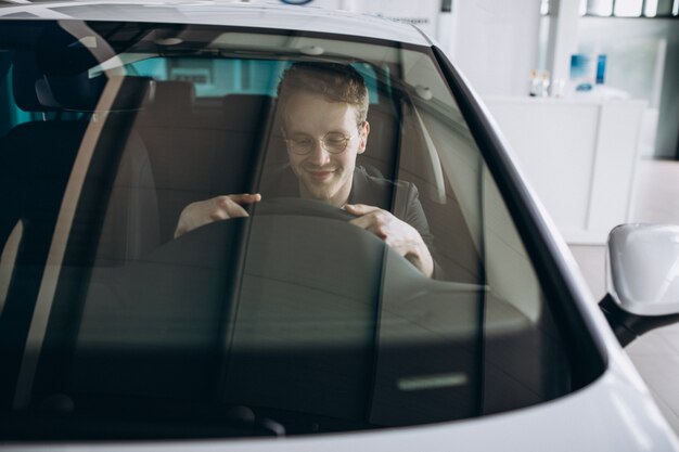 Hombre guapo sentado en un coche