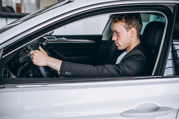 Hombre guapo sentado en un coche