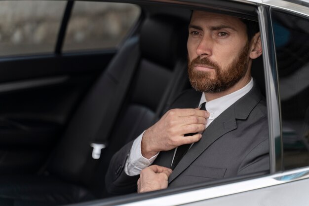 Hombre guapo sentado en la parte trasera de un taxi