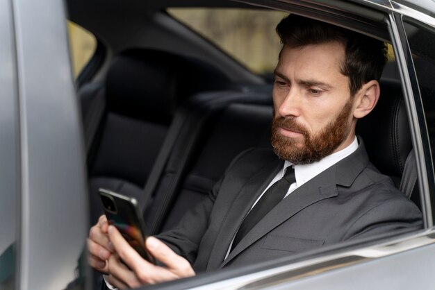 Hombre guapo sentado en la parte trasera de un taxi