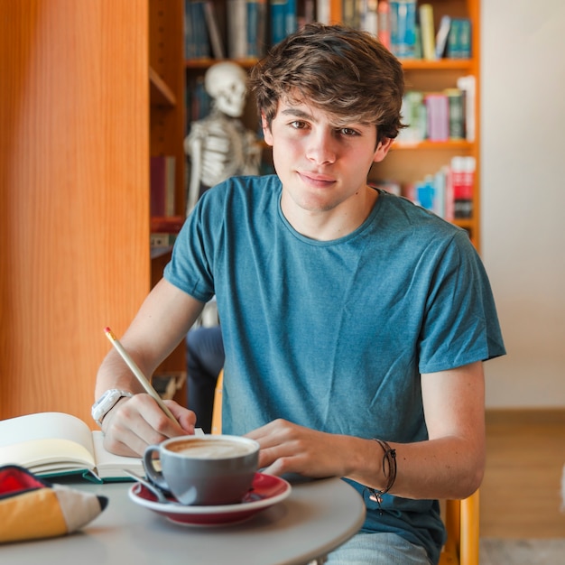 Hombre guapo sentado en la sala de lectura