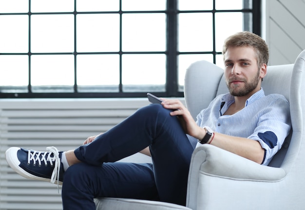 Hombre guapo sentado en el sillón