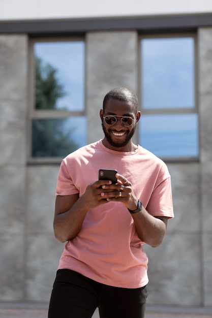 Hombre guapo con smartphone moderno al aire libre