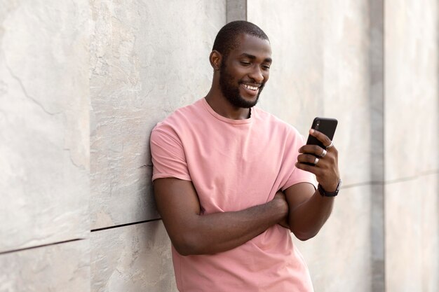 Hombre guapo con smartphone moderno al aire libre