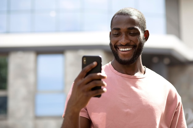 Hombre guapo con smartphone moderno al aire libre