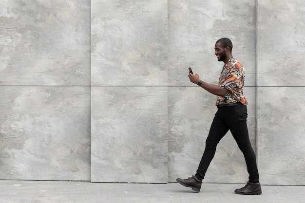 Hombre guapo con smartphone moderno al aire libre