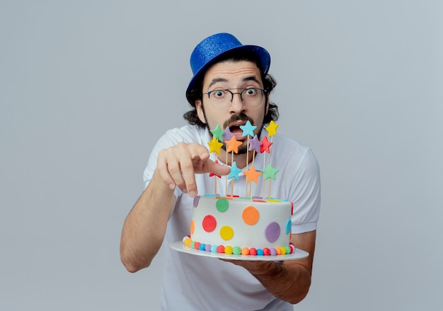 Foto gratuita hombre guapo sorprendido con gafas y sombrero azul sosteniendo pastel y mostrando gesto aislado en blanco