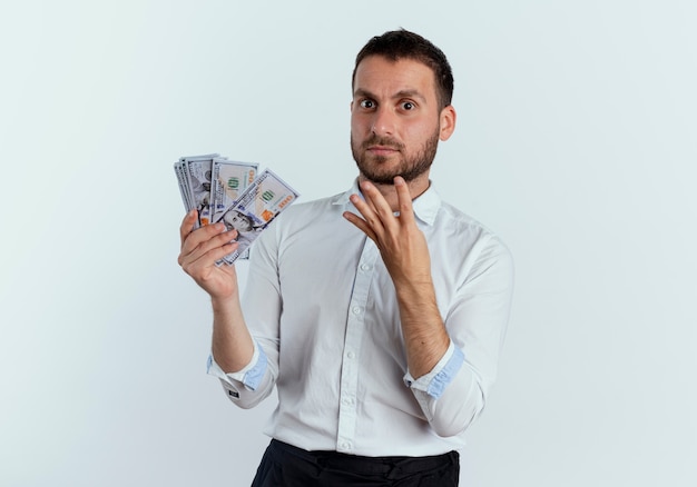 Foto gratuita hombre guapo sorprendido tiene dinero y gestos cuatro con la mano aislada en la pared blanca