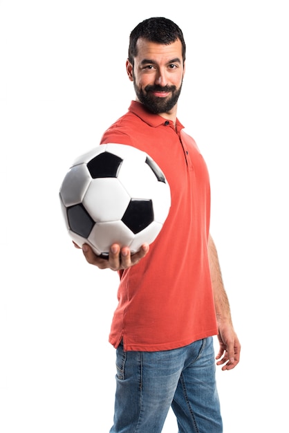 Foto gratuita hombre guapo sosteniendo un balón de fútbol