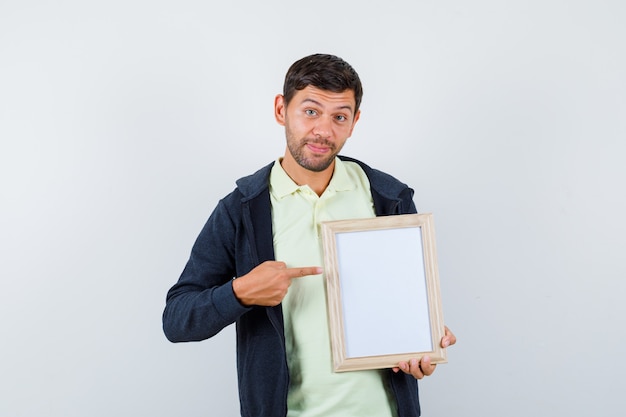 Hombre guapo sosteniendo un marco de fotos con un traje casual