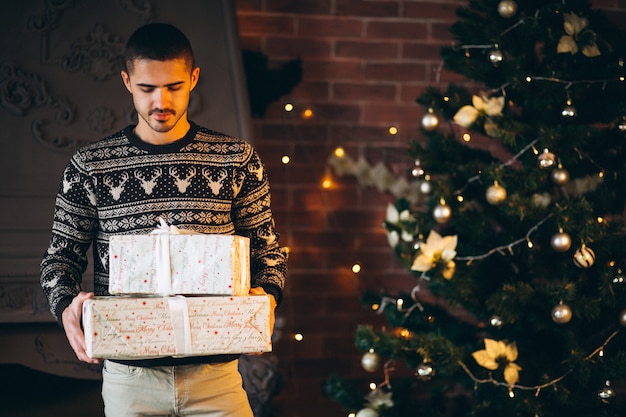 Foto gratuita hombre guapo sosteniendo navidad peresents