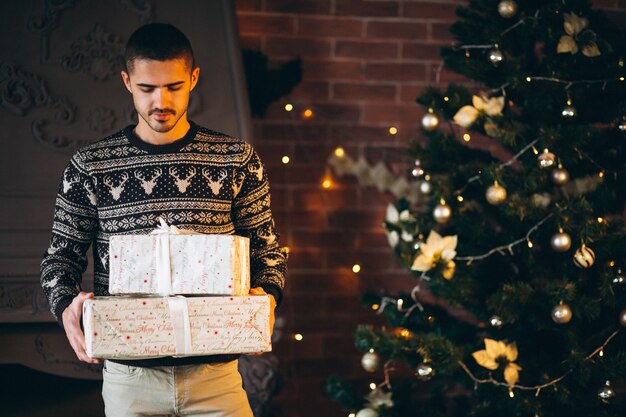 Hombre guapo sosteniendo Navidad peresents