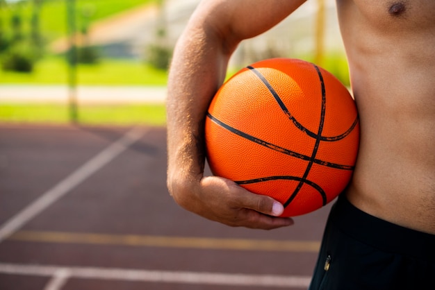 Foto gratuita hombre guapo sosteniendo una pelota