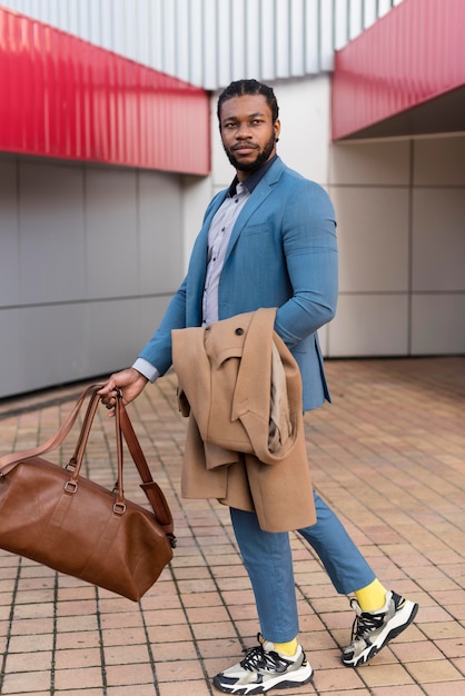 Foto gratuita hombre guapo sosteniendo su bolso