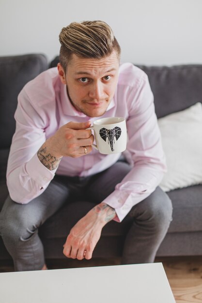 Hombre guapo sujetando una taza de café